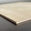 A close-up, angled view of a thin sheet of plywood. Produktbild-Vorschau