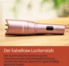 A rose gold cordless curling iron is placed on a wooden surface, with text describing its features. Náhled obrázku produktu