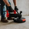 A person is using a concrete grinder on a floor. Produktbild-Vorschau