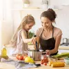 A mother and daughter are in a kitchen, preparing food together. The daughter is holding a kitchen utensil and stirring something in a pot, while the mother smiles and watches her. Produktbild-Vorschau