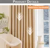 A close-up of beige curtains with a subtle striped pattern, shown in a living room setting with a chair and a window view of a snowy landscape. Náhled obrázku produktu