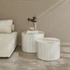 Two round coffee tables with a marble-like finish are placed next to a cream-colored sofa in a room with a textured wall and a rug. Anteprima dell’immagine prodotto
