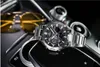 A watch and sunglasses are placed on a car's center console. Produktbild-Vorschau