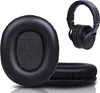 A close-up of black headphone ear pads and a pair of black headphones. Produktbild-Vorschau