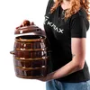A person is holding a brown ceramic fermentation pot with a lid. Voir les images du produit
