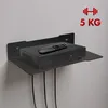 A black metal shelf mounted on a light gray wall, holding a black satellite receiver and a black remote control. Podgląd zdjęcia produktu