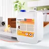 A large white plastic container of bioethanol is placed in a modern living room setting with a fireplace and furniture. Produktbild-Vorschau