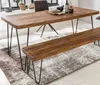 A wooden dining table and bench set with metal legs, placed on a rug in a room. Produktbild-Vorschau