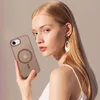 A woman is holding a phone case with a magnetic ring for MagSafe. Anteprima dell’immagine prodotto