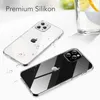 Two clear phone cases are displayed on a white and light gray surface, with water droplets scattered around one of them. A glass with lemon and water is visible in the background. Podgląd zdjęcia produktu