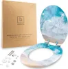 A toilet seat with a beach and ocean wave design, displayed next to its packaging and mounting hardware. Produktbild-Vorschau