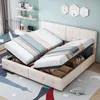 A bedroom scene with a bed that has storage compartments open, revealing bedding and pillows. There is a desk and shelves in the background. Produktbild-Vorschau
