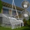 A white hammock chair with cushions is shown hanging in a garden setting, with a house in the background. Two circular diagrams illustrating the chair's rotation are present in the upper right corner. Produktbild-Vorschau