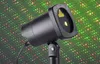 A black laser light projector is shown against a background of red and green laser dots. Náhľad obrázku produktu