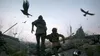 Two figures, one adult and one child, are running through a desolate landscape littered with dead bodies and debris. Crows fly overhead. Produktbild-Vorschau