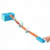 A Hot Wheels track set with a car on the track, and a hand pressing a button. Náhled obrázku produktu