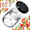 A clear glass jar with a black lid, surrounded by fresh vegetables and herbs. Podgląd zdjęcia produktu