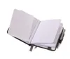 An open notebook with a pen attached to the side, set against a white background. Produktbild-Vorschau