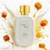 A perfume bottle is surrounded by splashes of milk and caramel cubes. Anteprima dell’immagine prodotto