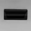 A close-up view of a black handle on a stainless steel surface. Náhled obrázku produktu