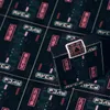 A close-up, angled view of a deck of playing cards with a cyberpunk-themed design, set against a background of similar card backs. Voir les images du produit