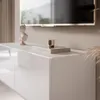 A close-up view of a white, high-gloss TV lowboard with decorative items on top. Voir les images du produit