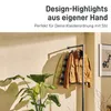A clothing rack with jackets and a plant in a room. Produktbild-Vorschau