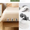 A collage showing bed sheet securing clips attached to a bed, with close-up views of the clips. Produktbild-Vorschau