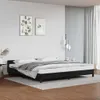 A bedroom scene with a black bed frame and white bedding. Náhled obrázku produktu