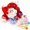 A Santa Claus Christmas stocking with several clear plastic balls filled with small toys and decorations scattered around it. Produktbild-Vorschau