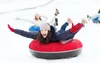 People tubing down a snowy hill. Produktbild-Vorschau