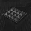 A close-up view of a black textured fabric with a diamond-shaped emblem featuring a grid of raised triangles. Náhled obrázku produktu