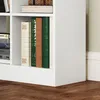 A close-up view of a white bookshelf with several books on its shelves. Náhľad obrázku produktu