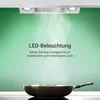 A kitchen range hood with LED lights illuminating a frying pan on a stovetop. Produktbild-Vorschau