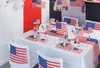 A table decorated for a patriotic celebration with American flags, streamers, and themed tableware. Náhled obrázku produktu