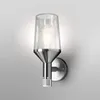 A modern wall-mounted outdoor light fixture with a clear glass shade and a brushed metal base, featuring a motion sensor. Produktbild-Vorschau
