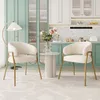 Two white upholstered chairs with gold metal legs are placed in a modern kitchen setting with mint green cabinets and a speckled backsplash. Náhľad obrázku produktu