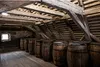A dimly lit attic or cellar filled with wooden barrels. Anteprima dell’immagine prodotto
