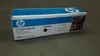 A product box for an HP toner cartridge is shown on a gray surface. Náhled obrázku produktu