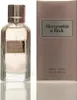 A bottle of Abercrombie & Fitch First Instinct Eau de Parfum for Women and its packaging are displayed side-by-side against a white background. Náhľad obrázku produktu
