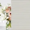 A bouquet of flowers in a vase is placed next to a striped pattern. Produktbild-Vorschau