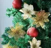 Close-up of artificial poinsettia flowers and red baubles decorating a Christmas tree. Podgląd zdjęcia produktu