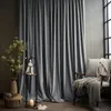A room interior with large grey curtains, a chair with blankets, and decorative items. Produktbild-Vorschau