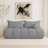 A modern living room scene featuring a gray bouclé sofa with decorative pillows and a piece of abstract art on the wall. Podgląd zdjęcia produktu