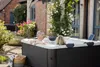 A couple relaxing in a hot tub in a garden setting. Produktbild-Vorschau