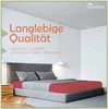 A bed with a red fitted sheet and gray bedding in a modern room. Produktbild-Vorschau