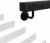 A black metal handrail with "100 cm" embossed on it, mounted on a white wall above white stairs. Náhľad obrázku produktu