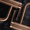 A close-up view of copper-colored faucet handles with ribbed detailing against a dark, textured background. Náhľad obrázku produktu