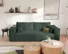A modern living room with a green corduroy sofa, coffee tables, and a framed poster on the wall. Voir les images du produit