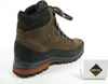 A brown hiking boot is shown on a white background, with a small box with a Gore-Tex logo in the lower right corner. Podgląd zdjęcia produktu